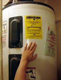 Plumber in Grapevine Texas surveys a water heater before a repair